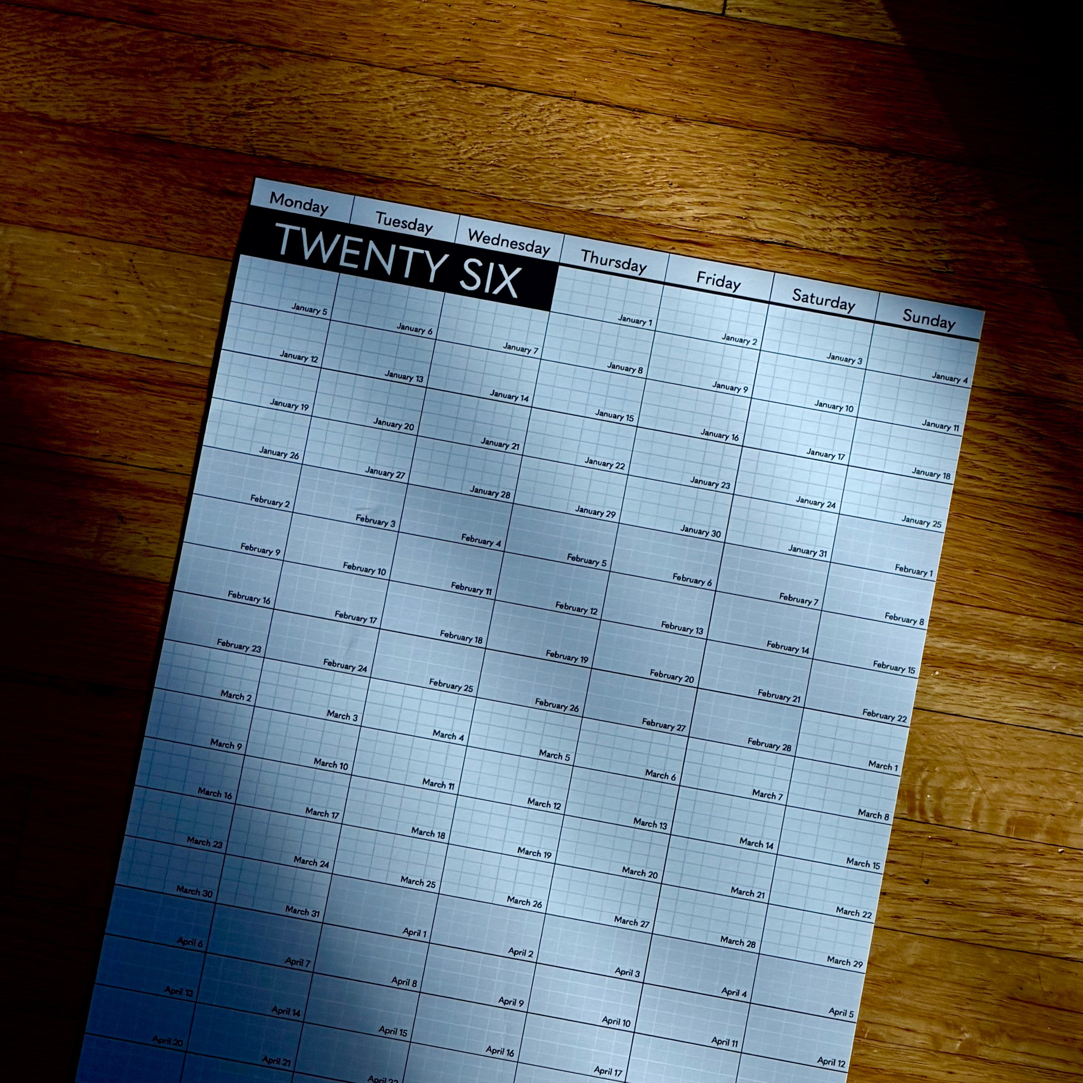 Calendar sheet labeled 'Twenty Six' on a wooden surface 